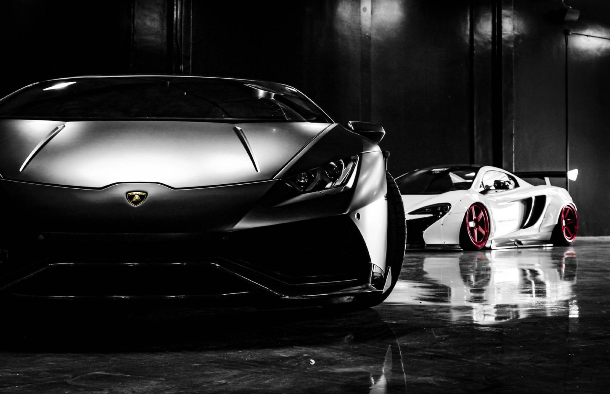 Glossy supercars detailed to a deep shine in a dark studio